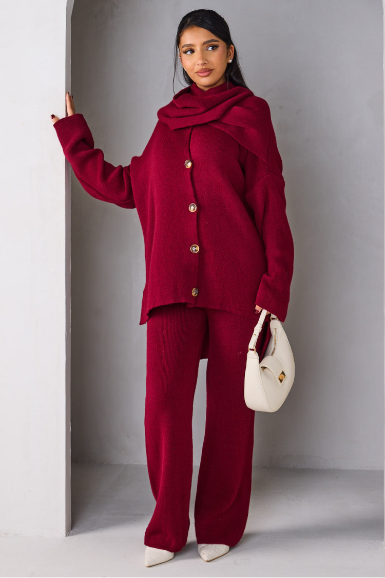 Three-piece knit co-ord set featuring a buttoned cardigan, matching trousers, and a coordinating scarf, styled with a minimalist white bag.