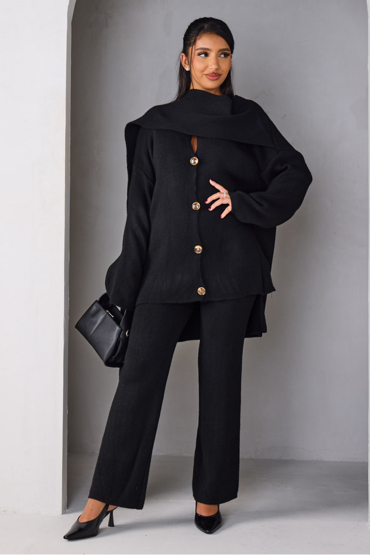 Three-piece knit co-ord set featuring a buttoned cardigan, matching trousers, and a coordinating scarf, styled with a minimalist white bag.